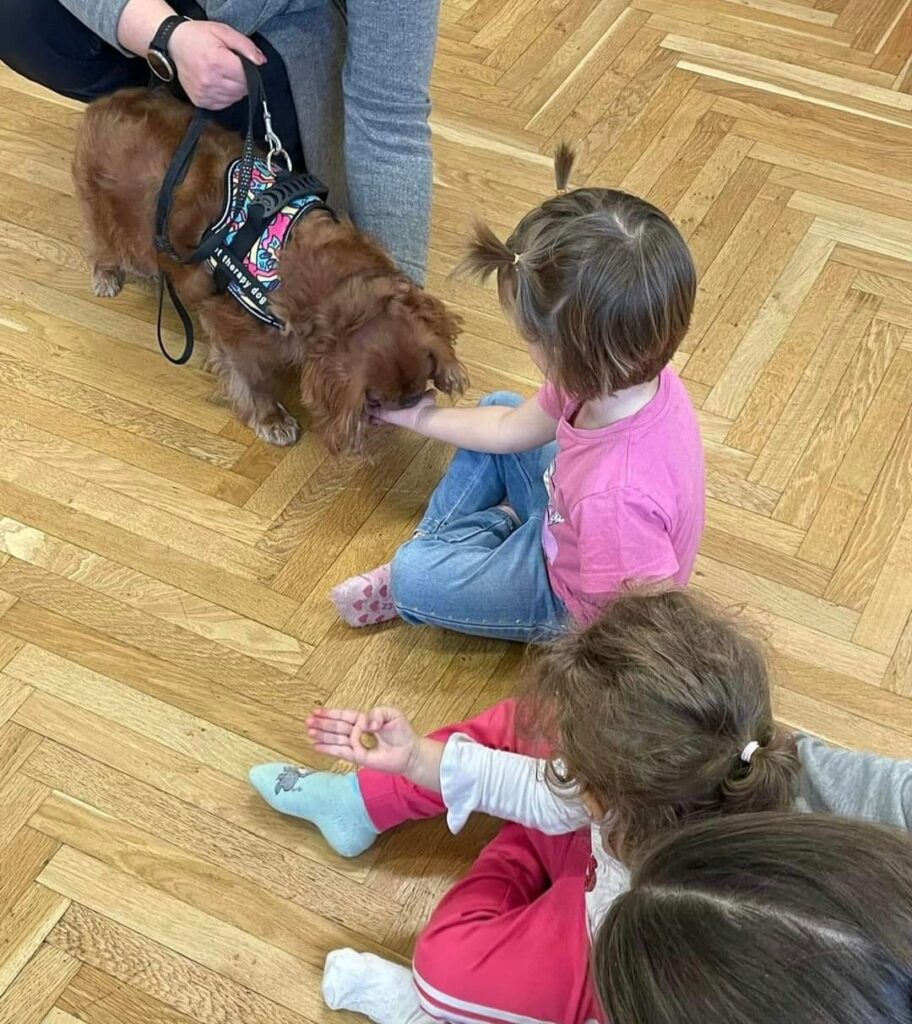 foto di bambine con un cane durante  una sessione di pet therapy di Come Una Piuma